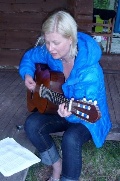Sanna accompagning her singing with a guitar. 